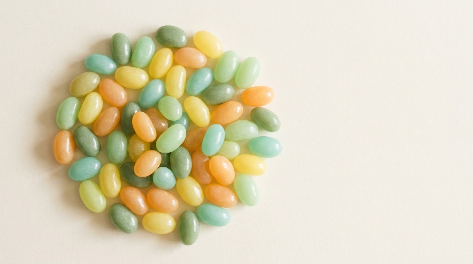 A cluster of pastel jelly beans grouped together on a pale background